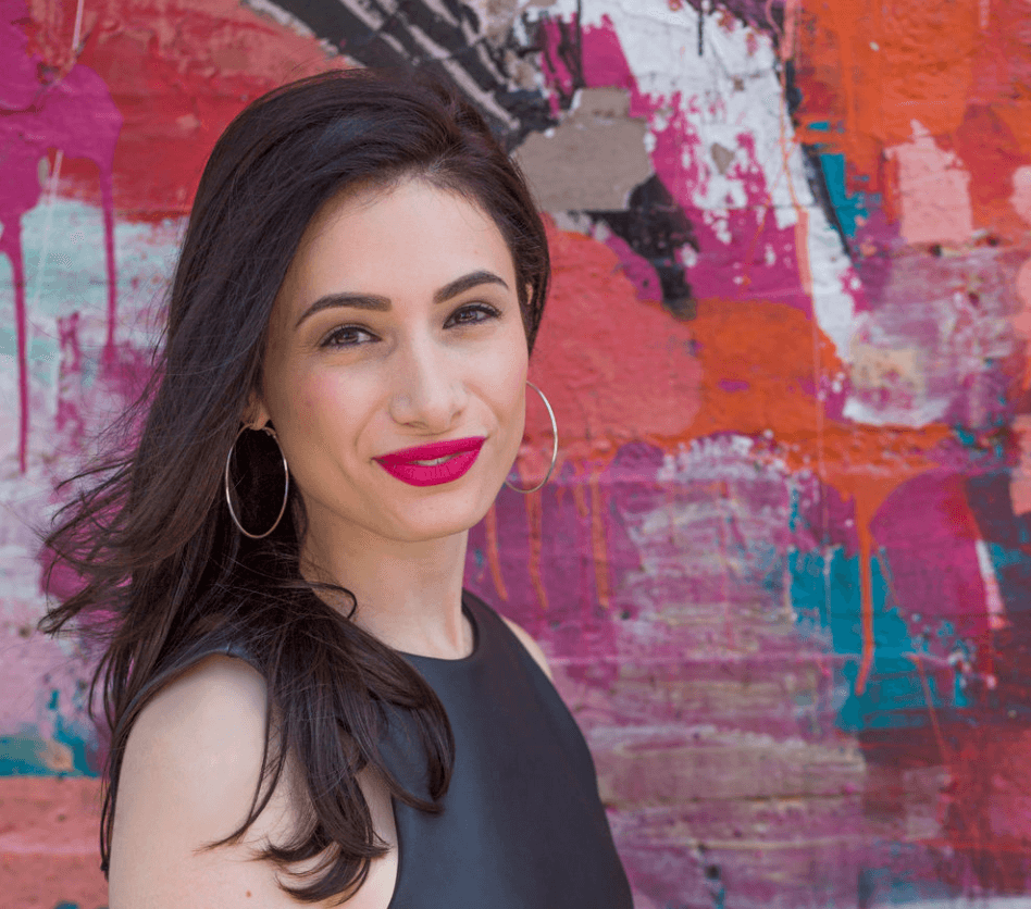 An image of a light-skinned woman named Melanie Cristol, smiling with long dark hair in front of a pink, blue, and orange background.